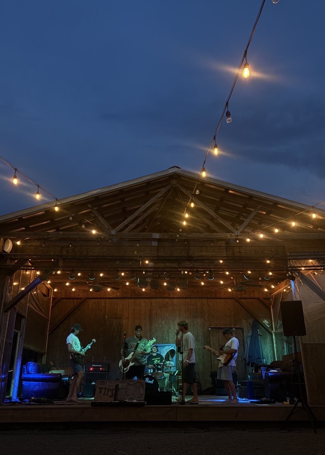 Late Dues performing under string lights